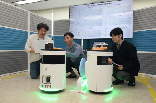 ETRI 연구진이 '듀얼사이드 무선충전 시스템'으로 두 대의 로봇을 충전하고 있다.  ETRI 제공